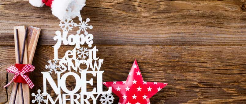 decorated Christmas quotes against a wooden backgorund