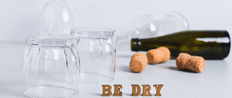 an empty bottle, glasses and corks to represent the dry january experience